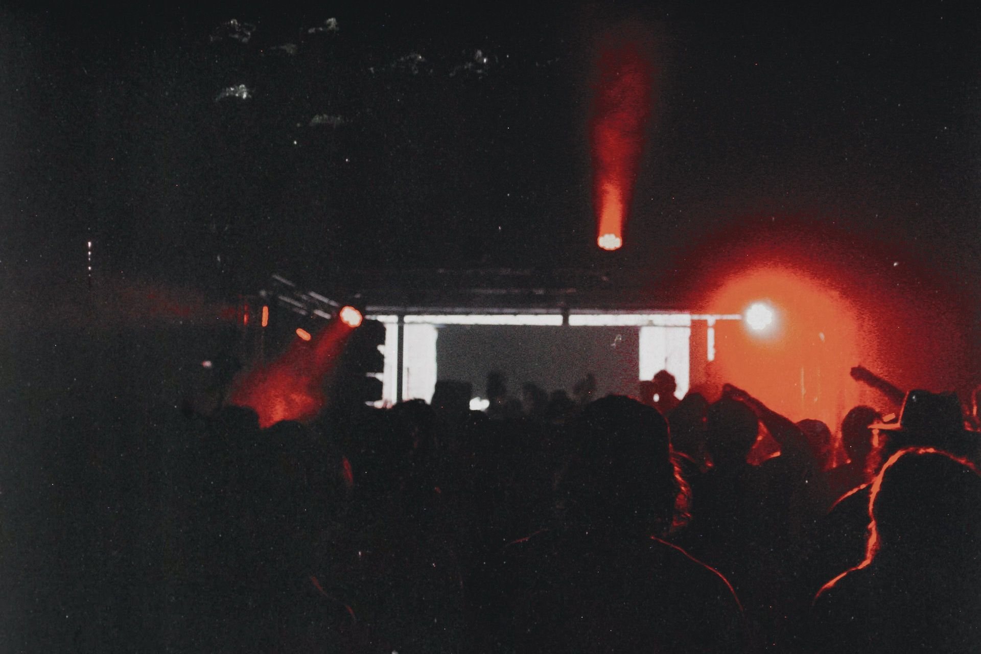 A packed underground crowd facing the stage.