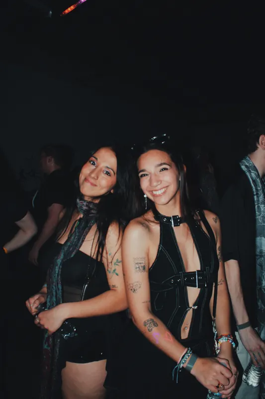 Two guests stand together in the dark room.