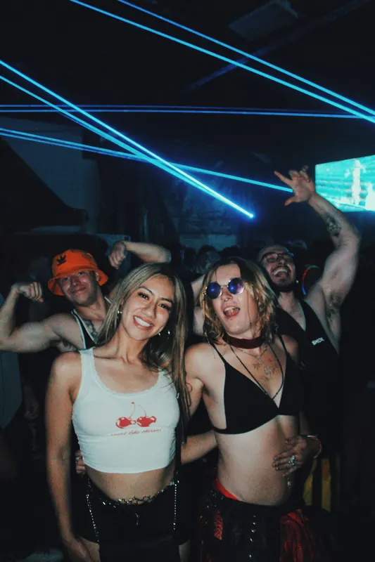 Guests pose beneath blue laser beams.