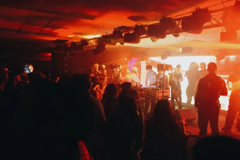 Guests face the decks in an orange-lit room.