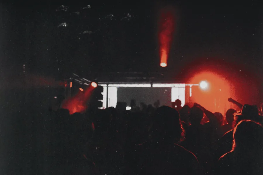 A packed Bunker crowd facing a red-lit stage.